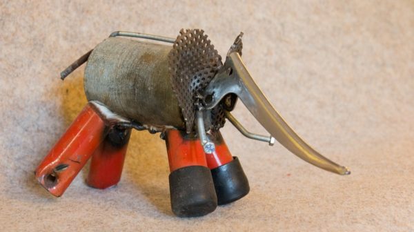 Une petite sculpture d'éléphant rouge en métal de récupération